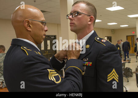 Staff Sgt Jason J. Garza, 419th Transportation Company motor Verkehrsunternehmer aus Salt Lake City, Utah, passt sich Sgt. Lance J. Clifford, Headquarters und Headquarters Company, 364th Expeditionary Sustainment Command Intelligence Analyst von Marysville, Washington, binden vor Cliffords Board Auftritt auf der US-Armee Reserve beste Krieger Wettbewerb 2014 am Joint Base McGuire-Dix-Lakehurst. Zweiundvierzig Junior trat Soldaten und Unteroffiziere in der Reserve im Wettbewerb an der Veranstaltung, welche Herausforderungen ihre körperlichen, geistigen und taktische Fähigkeiten Reservesoldat gewinnen eine Stockfoto