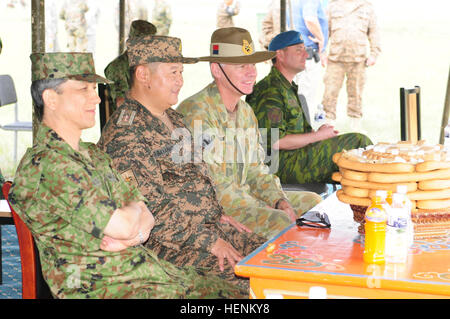 Gen Kiyofumi Iwata, Chef des Stabes der Japan Ground Self-Defense Force, Maj Gen.  B. Bayarmagnai, stellvertretender Generalstabschef der mongolischen Streitkräfte und Generalmajor Richard M. Burr, stellvertretender Kommandierender General, Operationen, US Army, Pacific, beobachten die Mini-Nadaam Feierlichkeiten aus der Kopftabelle nach einem ereignisreichen Tag ihre Truppen, die Durchführung von Schulungen im Rahmen des Khaan Quest 2014 27. Juni auf fünf Hügeln Trainingsbereich, Mongolei. Naadam ist eine traditionelle mongolische Festival vom 11. bis 13. Juli jeden Sommer.  Es besteht aus mongolischen Ringen, Pferderennen und Bogenschießen.  Als Zeichen der Zurückgezogenheit Stockfoto