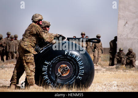 Ein Soldat steht neben dem Kursleiter, wie sie für den CH-47F Chinook Schwerlast-Hubschrauber, Gemeinkosten im Rahmen des Sling Training laden zu warten. (Foto von Sgt. Michael K. Selvage, 10. Sustainment Brigade Öffentlichkeitsarbeit NCO) (Freigegeben) Fracht-Prep 140630-A-CA521-307 Stockfoto