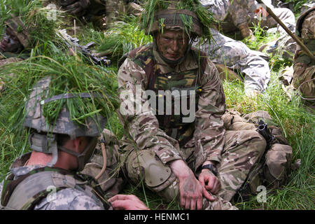 Britische Armee Royal Military Academy Sandhurst jüngsterer Sohn Sam Scott und West Point Military Academy jüngsterer Sohn Jonathan Hunter, Lockhart, Texas, native, sprechen, während sie ihrerseits auf die individuelle live-Feuer-Schulung warten. Sandhurst und West Point Kadetten absolvierte ihren zweiten Tag einer gemeinsamen zweiwöchigen Feld Übung mit live-Heißausbildung. Die Übung bestand aus einzelnen und Kader Bewegungen auf Palette 204 auf dem Truppenübungsplatz Grafenwöhr in der US-Armee 7. Armee Joint Multinational Training Command, Juli 8. Kadetten aus Sandhurst absolvieren ihre letzte Feld Bewegung und 50 West Poi Stockfoto