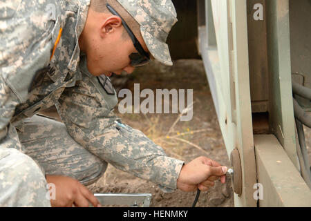 US Army Spc. Theodore Delmo 744th Engineering-Unternehmens gilt Fett für verschiedene Gelenke auf einer M60A1 Armored Vehicle startete Brücke am 14. Juli 2014 auf Fort Hunter Liggett, Calif. Dieses Kettenfahrzeug wurde verwendet, um zu halten und eine 2-Tonnen-Landbrücke in weniger als 5 Minuten bereitstellen. (US Armee-Foto von Spc. Derek Cummings/freigegeben) 744th Ingenieurbüro 140714-A-mc287-478 Stockfoto