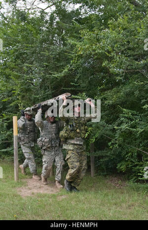 Kanadier / Sgt. Isaac Anderson, 33. kanadischen Brigade Group aus Ottawa, Ontario und U.S. Army Reserve Soldaten Sgts. Christopher Manley, eine allgemeine Ausrüstung-Operator und Portland, Oregon/USA, ansässig, und Carlos Lopez, ein Aufklärungs-Sergeant aus Vancouver, Washington, beide mit dem 671st Ingenieur-Unternehmen aus Portland, Oregon/USA, tragen einen Wurf mit einem mock Casaulty über ihren Köpfen simulieren, obwohl Wasser beim konkurrieren in einem Hindernis-Parcours-Wettbewerb im Rahmen der Operation Fluss Angriff auf Fort Chaffee zu überqueren , Arche, July16. Das Gerät konkurrierten untereinander für die schönste Zeit in der Szenario-simu Stockfoto