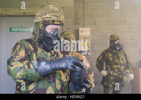 Ein britischer Flieger zugeordnet zu den obersten Hauptquartier der Alliierten Mächte Europa prüft die Abdichtung von seinem Kürbis in der US Army Training Support Center Benelux betriebene bakteriologischer, radiologische, chemische und nukleare (CBRN) Kammer auf Chièvres Air Base, Belgien, 23. Juli 2014. Britische Kräfte, die verschiedenen Einheiten der NATO oder der Form ausgebildet unter Aufsicht der britischen gemeinsamen europäischen Ausbildungsteam zugewiesen. (US Armee-Foto von visuellen Informationen Spezialist Pierre-Etienne Courtejoie / veröffentlicht) Zug der britischen Streitkräfte auf CBRN-Verfahren in einer US-Army-Anlage 140723-A-BD610-006 Stockfoto