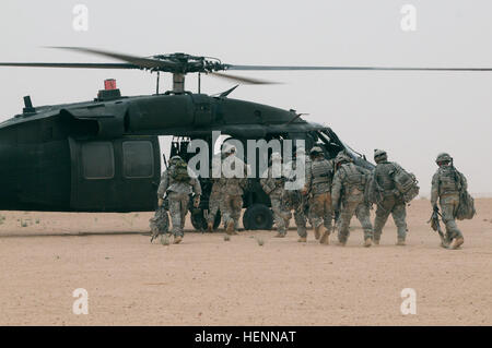 Nach der Reinigung des Ziels während der Operation Marauder Ernte in der desolaten westlichen Wüste des Salah Ad Din Provinz im Irak am 12. Apr, Soldaten aus der 56. Military Police Company und ihre irakischen s.w.a.t.-Pendants, bereiten einen UH-60 Black Hawk-Hubschrauber auf dem Weg zurück zu einer Koalition Basis zu laden. Handverlesenen durch Task Force Spartan Commander für außergewöhnlichen Service, Reserve MP Company Mission im Irak mit Full-Scale Luftangriff 84908 endet Stockfoto