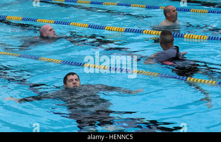 Charlie Company Soldaten zu beteiligen, das 100-Meter-Schwimmen in Uniform in einer Bemühung, die deutschen Streitkräfte Kenntnisse im Betrieb Sustainment Krieger 2014 gemeinsame Basis McGuire-Dix-Lakehurst, New Jersey OSW Abzeichen soll strenge und relevante Einzeltraining bieten, die Bereitschaft der Soldaten und Kundenbindung verbessert. (Foto: US Army Spc. Thomas X. Crough/veröffentlicht) OSW 2014 schwimmen in einheitlichen Test für die deutschen Streitkräfte Proficiency Abzeichen 140729-A-RU074-919 Stockfoto