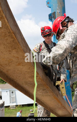 Alabama National Gardist Spc. Tod Rafferty (links), 440. chemische Firma Task Force 46, nutzt eine Planke, hörbare Geräusche zu kommunizieren, ein Überlebender, gefangen in der Struktur unter ihr während der Überlebende reagieren während der Übung lebendige Antwort 14, 2. Aug. um Camp Atterbury gemeinsame Manöver Training Center, ind.-Vibrant gefordert zu machen Antwort ist ein US Northern Command gesponsert , US Army North geführt, Feld Trainingsübung für chemische, biologische, radiologische, nukleare und High-Yield-explosive Folge Management Kräfte zur Verbesserung ihrer Fähigkeit zur Reaktion auf Catastrophi Stockfoto