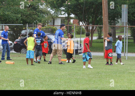 Soldaten zugewiesen Headquarters und Headquarters Troop, 3rd Armored Brigade Combat Team, 3. US-Infanteriedivision trennen die Jugend in Teams, um den letzten Tag des Lagers feiern bei den jungen und Mädchen Club Chattahoochee Tal, Columbus, Georgia, 1. August 2014 Fußballspielen. Letzten Tag des Sommer-Camp 140801-A-BZ612-004 Stockfoto