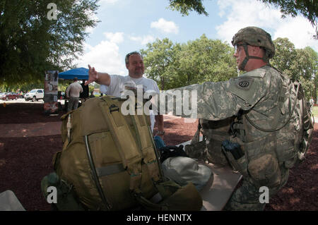 SPC. Kaleb K. Walbeck, Fallschirmjäger, die Firma C, 2. Bataillon, 501st Fallschirm-Infanterie-Regiment, 1st Brigade Combat Team, 82nd Airborne Division zugewiesen interagiert mit einem Mitglied der Gemeinschaft, 5. August, während der Fayetteville Technical Community College 13. jährliche North Carolina Verteidigung und wirtschaftliche Entwicklung Trade Show in Fayetteville, NC Walbeck, gebürtig aus Battle Creek, Michigan, besetzt eine Display auf der Messe seine Erfahrung als Infanterist mit der lokalen Gemeinschaft zu teilen. (Foto: U.S. Army Staff Sgt Mary S. Katzenberger) Teilen ihren Handel mit der Gemeinschaft 140805-A-RV Stockfoto