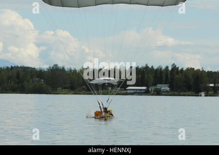 Ein Fallschirmjäger mit dem 4. Infantry Brigade Combat Team (Airborne), 25. Infanterie-Division, landet bei einem Wasser-Sprung aus einem Alaska Army National Guard UH-60 Black Hawk in Big Lake, Alaska, 6. August 2014. Der Wassergraben, Landung und Wiederherstellungsvorgang trugen um zu der Spartan Brigade breite Palette von luftgestützten Fähigkeiten weiter zu validieren. (Foto: US-Armee Sgt. 1. Klasse Jeffrey Smith/freigegeben) Arktis Spartaner springen in Big Lake 140806-A-ZX807-423 Stockfoto