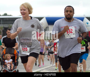 Mehr als 40 Soldaten, Zivilisten und Familienangehörige von der 81. regionalen Support Command schließe mehr als 2.800 der 4. jährlichen Run/Walk The verliebt in Fort Jackson, S.C. am 16. August. Die 5K Veranstaltung soll Hommage an die Opfer im Kampf zur Verteidigung der Nation und viele Teilnehmer tragen den Namen eines lieben Menschen auf ihre Läufer Bib. Hier abgebildet, geht Chief Warrant Officer 4 Brenda Bethany eine nicht identifizierte Läufer zu Beginn des Laufs. CW4 Brenda Bethany 140816-A-SC142-025 Stockfoto