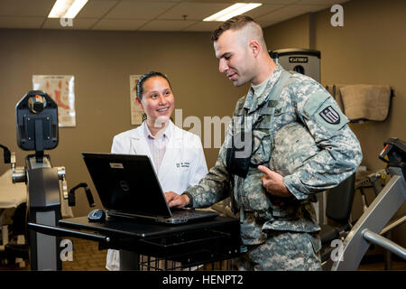 US Army Spc. Kevin Thomas, 863rd Pionier-Bataillon, zugewiesen interagiert mit Joni Garcia Hunter, ein Physiotherapie-Assistent mit der Gesundheit und Wellness-Abteilung am Argonne National Laboratory in Darien, Illinois, 26. August 2014 während ein Foto schießen, um Bürger-Soldaten in der Wissenschaft, Technik und Mathematik Industrien zu fördern.  (Foto: US-Armee Sgt. 1. Klasse Michel Sauret/freigegeben) US Army Spc. Kevin Thomas, 863rd Pionier-Bataillon, zugewiesen interagiert mit Joni Garcia Hunter, ein Physiotherapie-Assistent mit der Gesundheit und Wellness Abteilung am Argonne Nat Stockfoto