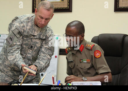 US Armee Command Sergeant Major Ronnie R. Kelley, links, der Senior Berater der US-Armee zentrale Coalition Forces Land Component Command eingetragen, zeigt Angeln Fotos zu Oberst Abdul Salem, der Kommandant von der Kuwait Ministerium der Verteidigung verkauften Offizier und Rekruten Training Institute, während der Tagung zur Diskussion neuer Ideen um Partnerschaft in Kuwait-Stadt, Kuwait, 27. August 2014 zu verbessern. Kelley lud eine Gruppe von Studenten der kuwaitischen Unteroffizier an der US-Armee Krieger Leader Kurs um Partnerschaft Kapazitäten aufzubauen und zu verbessern Partner Nation Interoperabilität, Kapazität Stockfoto