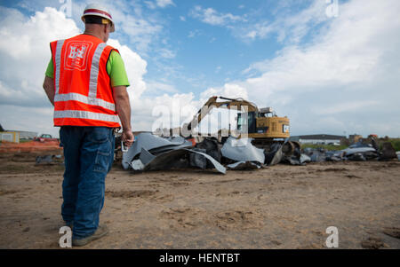 United States Army Corps of Engineers Bau Koordinator Dennis Mayer betreut belgische Unternehmer, mit denen die 5000 + PSI Abriss Scherung Kiefer eine nachverfolgte Hydraulikbagger um stillgelegten Jet-Treibstoff-Tanks um Schiff und recyceln an Chièvres Air Base, Belgien, 18. September 2014 auseinander zu nehmen.  (US Army Foto von visuellen Informationen Spezialist Pierre-Etienne Courtejoie veröffentlicht) POL Panzer Abriss und recycling 140918-A-BD610-079 Stockfoto