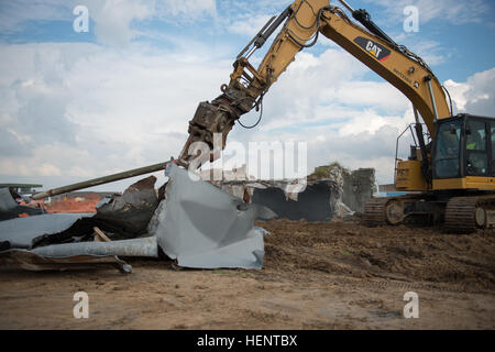 Belgischer Unternehmer bewegen ein Metallrohr mit dem 5000 + PSI Abriss Scheren Kiefer eine nachverfolgte Hydraulikbagger, wie sie auseinander zu nehmen, stillgelegten Jet-Treibstoff-Tanks um Schiff und recyceln an Chièvres Air Base, Belgien, 18. September 2014. (US Armee-Foto von visuellen Informationen Spezialist Pierre-Etienne Courtejoie-freigegeben) POL Panzer Abriss und recycling 140918-A-BD610-086 Stockfoto