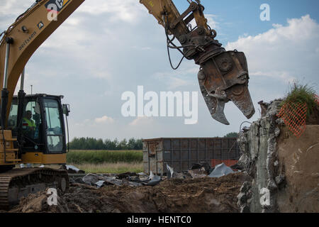 Die 5000 + PSI Abriss Scherung Kiefer eine nachverfolgte Hydraulikbagger gesteuert durch belgische Unternehmer sollen Rippen auseinander stillgelegten Jet-Treibstoff-Tanks um Schiff und recyceln an Chièvres Air Base, Belgien, 18. September 2014. (US Army Foto von visuellen Informationen Spezialist Pierre-Etienne Courtejoie veröffentlicht) POL Panzer Abriss und recycling 140918-A-BD610-098 Stockfoto