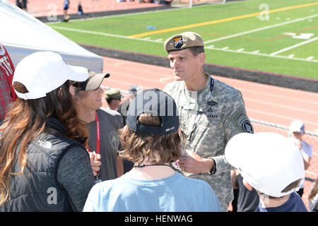 Armee-General Joseph Votel, Kommandeur des US Special Operations Befehl (USSOCOM), grüßt Familie, die Mitglieder des Teams USSOCOM, Okt. 2, während der Leichtathletik Teil der Krieger Spiele 2014 in Colorado Springs, Colorado Athleten aus der USSOCOM Adaptive Sportprogramm gegen Teams aus allen Branchen in Colorado Springs aus 28 Sept., Okt. 4 konkurrieren. Die Krieger Spiele, gegründet im Jahr 2010 sollen Heilung und Genesung der Verwundeten, Kranken und verletzten Soldat innen und Veteranen durch adaptive Sport zu unterstützen. US Special Operations Command-Team, Krieger Spiele 2014 141002-A-JJ202-902 Stockfoto