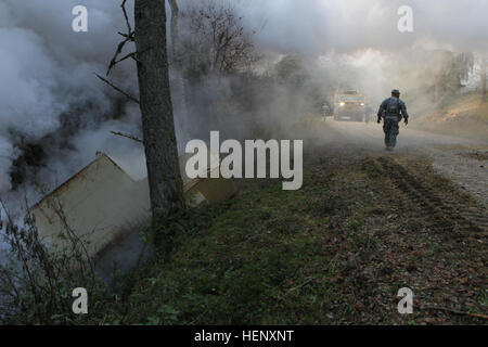 Ein US-Soldat, rechts, das Adler-Team, gemeinsame Multinational Readiness Center (JMRC) (Operations Group), nähert sich US-Soldaten, der 115. Brigade Support Battalion, 1st Brigade Combat Team, 1. Kavallerie-Division, wie sie in Richtung eines abgestürzten Fahrzeuges voraus, die durch eine simulierte improvisierte explosive Vorrichtung während heimgesucht wurden Übung kombiniert zu beheben III an die JMRC in Hohenfels, Deutschland, Okt. 28 , 2014. Kombinierte Lösung III ist eine multinationale Übung, die enthält mehr als 4.000 Teilnehmer aus NATO und Partner, und soll eine komplexe Trainingsszenario bieten, die sich Stockfoto