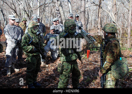 US-Armeesoldaten aus dem 2. Bataillon, 1. Infanterie-Regiment, 2nd Stryker Brigade Combat Team, 2. Infanterie-Division von Joint Base Lewis-McChord, Washington, und Japan Ground Self-Defense Force Mitglieder aus 11. Infanterie-Regiment, 7. Panzer-Division, Nordarmee Austausch Techniken verwendet, um Personal und Geräte im Falle einer Exposition gegenüber chemischen Stoffen, Okt. 28 dekontaminieren.  Die Einheiten sind Orient Shield 14, 27 Okt. – 7. November beteiligt. US-Armee und JGSDF Austausch chemischer decon Techniken im Orient Shield 14 141028-A-WG123-001 Stockfoto