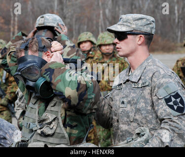 US-Armeesoldaten aus dem 2. Bataillon, 1. Infanterie-Regiment, 2nd Stryker Brigade Combat Team, 2. Infanterie-Division von Joint Base Lewis-McChord, Washington, und Japan Ground Self-Defense Force Mitglieder aus 11. Infanterie-Regiment, 7. Panzer-Division, Nordarmee Austausch Techniken verwendet, um Personal und Geräte im Falle einer Exposition gegenüber chemischen Stoffen, Okt. 28 dekontaminieren.  Die Einheiten sind Orient Shield 14, 27 Okt. – 7. November beteiligt. US-Armee und JGSDF Austausch chemischer decon Techniken im Orient Shield 14 141028-A-WG123-004 Stockfoto