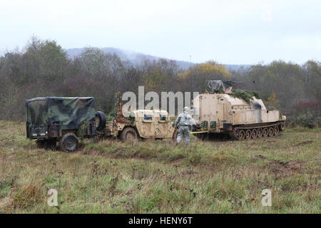 US-Soldaten von Charlie Batterie, 1. Bataillon, 82. Feldartillerie-Regiment, 1st Brigade Combat Team, 1. Kavallerie-Division-Nutzung eine M992 Field Artillery Munition liefern Fahrzeug einen Humvee während Abschleppen Übung kombiniert zu beheben III bei der Joint Multinational Readiness Center in Hohenfels, Deutschland, 6. November 2014.  Kombinierte Lösung III ist eine multinationale Übung, die enthält mehr als 4.000 Teilnehmer aus NATO und Partner, und soll eine komplexe Trainingsszenario bieten, die konzentriert sich auf multinationale unified Land Operationen und stärkt das US-Engagement für NATO und Euro Stockfoto
