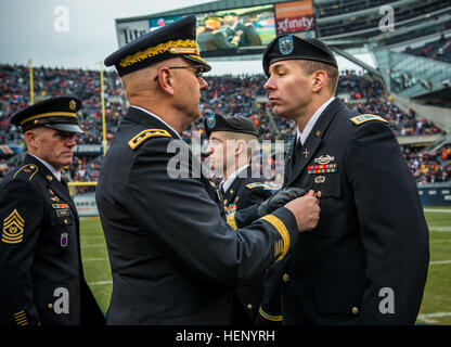 Captain Ryan Wherfel, erhält Bronze Star von Generalleutnant Michael S. Tucker, Kommandierender general des ersten US-Armee, mit Hauptsitz in Rock Island Arsenal, Ill., neben Kapitän Tristan Myers, beide Empfänger mit der Illinois Army National Guard. Wherfel ist vom 1. Bataillon, 178th Infanterie-Regiment, 33. Infantry Brigade Combat Team; und Myers ist vom 2. Bataillon, Infanterie-Regiment 130., 33. Infantry Brigade Combat Team. Die Zeremonie fand in der Halbzeitpause bei einem NFL-Spiel im Soldier Field, Truppen am 16. November, wenige Tage nach Veterans Day in Chicago zu Ehren benannt. (US-Ar Stockfoto