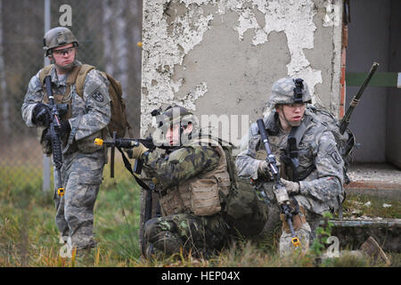 (Von links nach rechts) Eines US-Soldaten mit 131. militärischer Arbeitshund Ablösung, 615th Military Police Company, der 43. Tschechische Airborne Battalion und ein US-Fallschirmjäger mit 1. Eskadron, 91. Kavallerieregiment 173rd Airborne Brigade führen durch einen Angriff in einem städtischen Umfeld bei der 7. Armee gemeinsame multinationale Ausbildung des Befehls Grafenwöhr Truppenübungsplatz, Deutschland, 20. November 2014. Die Ausbildung ist Bestandteil eines einwöchigen Trainings gehostet von der Squadron, Führer der Planung und Durchführung von zeitkritischen Vorgängen Lehren soll. (US Army Foto von visuellen Informationen Spezialist Gertrud Stockfoto