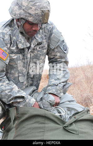 Pv2 Alex Dickerson, erholt sich von 1-319 Hauptsitz und zentrale Batterie Fallschirm nach einem Sprung auf Sizilien Drop-Zone, Fort Bragg, N.C., für die 17. jährliche Randy Oler Memorial Betrieb Spielzeug fallen, moderiert von US Armee zivile Angelegenheiten & psychologische Operations Command (Airborne), 6. Dezember 2014. Betrieb Spielzeug fallen ist die weltweit größte Luft Mischbetrieb und Soldaten die Möglichkeit zu helfen, Kinder in Not Spielzeug für den Urlaub erhalten. (Foto: U.S. Army Spc. Lisa Velazco) US Army Soldier erholt Fallschirm 141206-A-QW291-126 Stockfoto