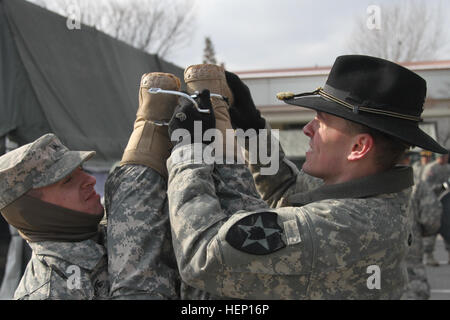 Soldaten vom 6. Geschwader, 17. Kavallerie-Regiment, 2nd Combat Aviation Brigade, 2. US-Infanteriedivision die Spurs aufsetzen Fellow Soldat, der gerade seine "Spur Ride" hier Dez. 11 beendet hat. Sporen des Augenblicks 121114-A-TU438-004 Stockfoto