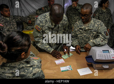 SPC. Guadalupe Shim, links, gebürtig aus Dallas und spec Brandon Carr, gebürtig aus Kinston, NC, Recht, beide Post Spezialisten für das 18. Human Resources Company, 82. spezielle Truppen Bataillon, 82. Sustainment Brigade unterstützen spec Randritz Hopper, Center, gebürtig aus Shelby, NC, und medizinische Logistik-Spezialist für 583rd medizinische Logistik-Unternehmen, 1. medizinische Brigade mit einem Paket, die er in die USA zurück von Roberts International Airport schickt , Monrovia, Liberia, am 22. Dezember 2014. Das Postamt am Roberts International Airport ist das erste voll funktionsfähige Armee Postamt o Stockfoto