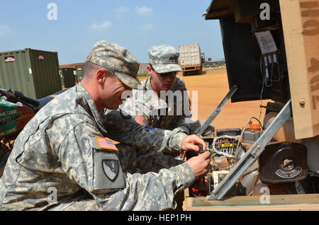 Sgt. Austin Lumpkin, links, ein Belle Chase, La., heimisch, und CPL James Lenke, West Seneca, New York, native, sowohl des Headquarters und Headquarters Company, 62. Pionier-Bataillon 36. Engineer Brigade, prüft auf einen Generator zum Zeitpunkt der Rückholsteuerung, 26. Dezember 2014, an der National Police Training Academy Paynesville, Liberia, zur Unterstützung der Operation Vereinigte Unterstützung. Als Teil ihrer Routine für den Bürgermeister Zelle sicherzustellen sie, dass der Generator betreibbar, Licht in der Nacht ist. Betrieb United Hilfe ist ein US-Verteidigungsministerium Betrieb in Liberia Logistik, Ausbildung einer Stockfoto