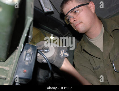 PFC. Jacob Gilmon, Leander, Texas, gebürtig, als ein Fahrzeug mit Rädern Mechaniker mit Unterstützung der Stabskompanie, spezielle Truppen Bataillon, 4. US-Infanteriedivision, Multi-National Division dient – Bagdad, kämpft mit einem schwierigen Schraube für das Rhino in einem Humvee Juni 11 am DSTB Motor Pool am Camp Liberty. Gilmon bereitete die alten Humvee in gedreht werden und ein neueres Modell eingetauscht. Tag im Leben, Rad-Fahrzeug Mechanik arbeiten Soldaten mobile 94010 zu halten Stockfoto