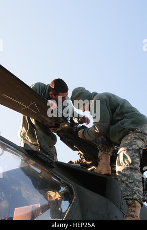 US Army Spc. Austin Bennett und Cadet Bryan Honeycutt führen routinemäßige Wartungsarbeiten auf ein AH - 64D Apache Longbow Hubschrauber während einer Fortbildungsveranstaltung Jan. 10 an der North Carolina National Guard Flug Anlage in Morrisville, NC Bennett und Honeycutt sind beide Soldaten der 1. Angriff Reconnaissance Battalion, 130. Aviation Regiment zugewiesen. (Foto: U.S. Army Captain Dave Chace, 449th Theater Aviation Brigade) Kompetenz ist ihre Devise, Nationalgarde Unteroffiziere halten NC Apache Gerät läuft 150110-A-GV060-976 Stockfoto