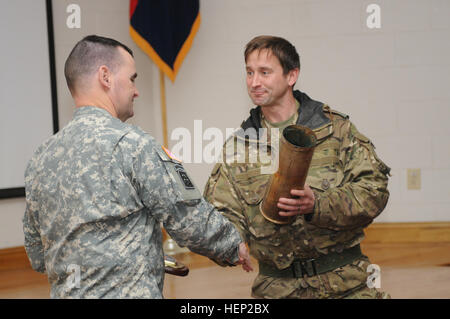 Major Justin Baker, Recht, Kommandeur der G Fallschirm Akku, 7. Fallschirm Royal Horse Artillery, präsentiert der 82nd Airborne Division Artillerie-Kommandeur Oberst Christopher Moretti mit dem abgebrannten 105 mm Haubitze Gehäuse von einer Runde, die er während der Operation Pegasus Cypher am Fort Bragg, N.C., 14. Januar 2015 aus eine L118 leichte Pistole abgefeuert. Die britischen Fallschirmjäger teamed oben mit Batterien aus dem 2. Bataillon, 319th Airborne Field Artillery Regiment für den Betrieb, kombinierte Taktiken, Techniken und Verfahren in der Vorbereitung für eine kombinierte gemeinsame operative Zugang Übung im April, die wi zu entwickeln Stockfoto