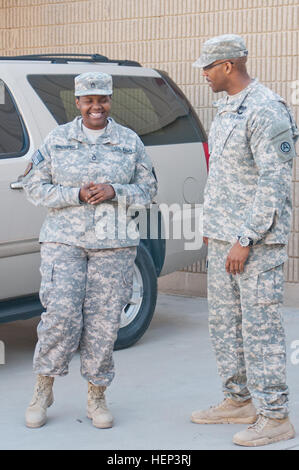 Zwei eingesetzte Soldaten teilen sich einen Moment vor dem Hauptquartier der gemeinsamen Streitkräfte in Camp Arifjan, Kuwait, und spiegeln die Kameradschaft während ihres Einsatzes wider. Stockfoto