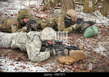 Ein US-Fallschirmjäger, 1. Staffel, 91. Kavallerieregiment, 173rd Airborne Brigade zugewiesen feuert seine M4 Karabiner mit Soldaten aus der deutschen Streitkräfte Vereinte Nationen Ausbildungszentrum, während einer kombinierten Übung auf dem Truppenübungsplatz der Infanterie in Hammelburg, Deutschland, 29. Januar 2015. Soldaten der Alliierten Nationen trainierten auf mehrere helle Infanterie-Waffen-Systeme während eines zweitägigen kombinierten Trainings um Interoperabilität zu verbessern. (US-Armee Foto von visuellen Informationen Spezialist Markus Rauchenberger/freigegeben) 1-91 CAV Waffen Qualifikation mit deutschen Partnern 150129-A-BS310-471 Stockfoto