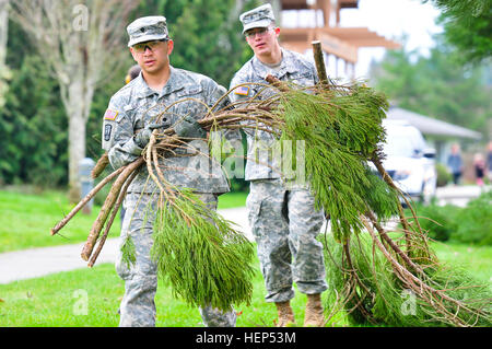 SPC. Daniel Quey (links) und Spc. Alex Chavoya (rechts), Radar-Werkstätten zugewiesen Firma D, 5. Bataillon, 5. Luft-Verteidigung-Artillerie, 17. Feldartillerie Brigade der 7. Infanteriedivision, aufsuchende Haul Zweige Schnitten sie vor kurzem von den Bäumen auf dem Campus Chloe Clark Elementary School in Dupont, Washington, als Bestandteil einer 17. Fires Brigade Gemeinschaft Unterstützung in einer Grundschule Sicherheit Bereinigung 18. Februar. Die Soldaten aufgeräumt auch der Cherrydale Primary School Campus in Steilacoom, Washington JBLM Soldaten Hilfe aufräumen örtlichen Grundschule Campus 150218-A-UG106-065 Stockfoto