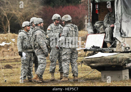 Dragoner, Archer Batterie Feldartillerie Geschwader zugewiesen 2. Kavallerie-Regiment teilnehmen, in einer live-Feuer-Übung, wo haben sie ihre M777 Haubitzen feuern Anweisungen zur Unterstützung der Troopers, 4. Sqdn, 2 zugewiesen und wartet auf weitere Anweisungen von ihrer Vorwärtsbeobachter die Zielerfassung Relais inszeniert, CR während ihres Fachs üben in Grafenwöhr Training Area, in der Nähe von Rose Barracks, Deutschland , 24. Februar 2015. FA-Geschwader, 2. Kavallerie-Regiment Leben Feuer Übung 150224-A-EM105-061 Stockfoto