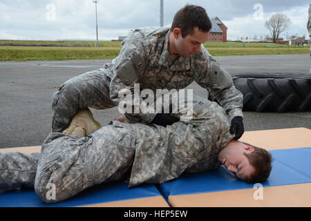 US Armee Sgt. Joe Primeau Allied Forces North Bataillon zugeteilt, sichert den Griff um den Körper von nicht konformen Person (Sgt. Jeffrey King, Allied Forces North Bataillon zugeordnet) zu überprüfen, während der taktischen Combatives Kurse Level 2, Parkplatz des Hangar 4 Erholung Gemeindezentrum, in Chièvres Air Base, Belgien, 24. Februar 2015. (US Armee-Foto von visuellen Informationen Spezialist Pascal Demeuldre veröffentlicht) Taktische Combatives Kurse Stufe II in Chièvres Air Base 150224-A-RX599-101 Stockfoto