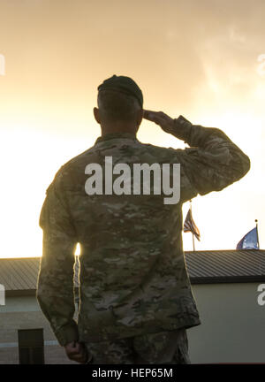 Ein Soldat aus der USASOC Befehl Fallschirm-Team, die schwarz-Dolche, salutiert während früh Tagwache bei Homestead Air Reserve Base, Florida Das Team mit Sitz in Fort Bragg, N.C., ist in FL für Vorsaison Demo Training. (Foto: US-Armee von Cheryle Rivas, USASOC Public Affairs) Morgen Gruß 150304-A-WI439-286 Stockfoto