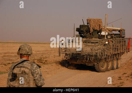 Soldaten, die Headquarters und Headquarters Company, 1. Bataillon, 27. Infanterie-Regiment "Wolfhounds," zugewiesen 2nd Stryker Brigade Combat Team "Krieger", 25. Infanterie-Division, Multi-National Division - Bagdad sichere Straßen mit Boden Truppen und Stryker gepanzerte Fahrzeuge während einer Artillerie-Kanone testen Feuer in einer abgelegenen Gegend in den Taji Qada, nordwestlich von Bagdad, Juli 5 liegt. Wolfhounds sicheren Test-Site 102636 Stockfoto