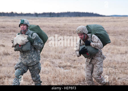 Major Aaron Williams (links), Brigade-Executive-Officer für die US-Armee Alaska 4th Infantry Brigade Combat Team (Airborne), 25. Infanterie-Abteilung und US Marine Staff Sgt Kevin Huff, mit 3. Luftförderung, Camp Foster, Okinawa, losfahren zum Montagebereich nach der Durchführung eines Kompetenz-Sprung aus einer CH-47 Chinook-Hubschrauber geflogen von 1st Battalion, 52. Aviation Regiment "Fliegende Drachen," auf der gemeinsamen Basis Elmendorf-Richardson , Alaska, 26. März 2015. (Foto von US Armee Sgt. Eric James Estrada/veröffentlicht) Spartaner springen von fliegenden Drachen 150325-A-ZD229-285 Stockfoto