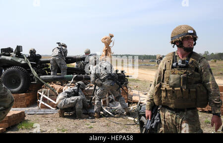 Britische Fallschirmjäger mit 7. Royal Horse Artillery, 3. Fallschirm-Regiment unterstützt die Soldaten mit 2nd Battalion, 319th Airborne Field Artillery Regiment, 82nd Airborne Division Artillerie während sie Deriged ihre M119A3 in der Vorbereitung für ein scharfer Munition aus der Drop-Zone. (Captain Joe Bush, 82nd Airborne DIVARTY/freigegeben) Schwere Tropfen 150409-A-BG594-005 Stockfoto