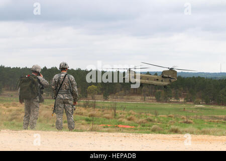 Fallschirmjäger sehen auf wie ein CH-47 Chinook-Hubschrauber von 10. Combat Aviation Brigade, bereitet Fort-Trommel, New York, während kombiniert gemeinsamen operativen Zugang Übung 15-01, Fort Bragg, 14. April 2015 auf Holland Drop-Zone landen. Fallschirmjäger von 2nd Brigade Combat Team, 82nd Airborne Division und dem Vereinigten Königreich 16 Air Assault Brigade, sind CJOAX 15-01, die größte multinationale Ausbildung hier in fast 20 Jahren durchgeführte Übung beteiligt. (Sgt. Matthew Britton, 27. Public Affairs-Abteilung) CJOAX 15-01 150414-A-CG673-033 Stockfoto