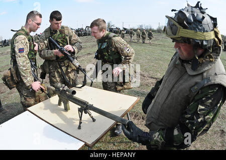 Britische Soldaten (links), zugeordnet zu den Coldstream Guards, schauen Sie sich ein Gewehr M4 Carbine während eines rumänischen Soldaten (rechts), die rumänische Armee zugewiesen, wirft einen Blick auf eine M110 semi-automatische Sniper System während der Anzeige von Troopers, 2. Geschwader zugewiesen 2. Kavallerie-Regiment, zeigt die Waffen, die sie zugeordnet sind und während des Trainings, nach der Teilnahme an der Eröffnungsfeier für Wind Frühjahr 2015 um Smardan Trainingsbereich , Rumänien, 16. April 2015. Die Wind Frühjahr 2015 Übung zielt auf Erhaltung und Steigerung der Interoperabilität zwischen den NATO-Verbündeten. (US Armee p Stockfoto