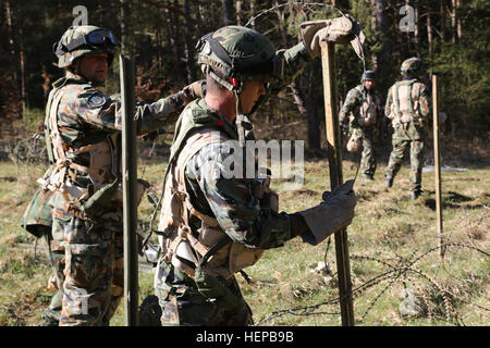 Bulgarische Soldaten des sicheren Stacheldrahtes Engineer Platoon Streikposten Stahl bei der Konstruktion ein Draht Hindernis während des Trainings Saber Kreuzung 15 an die US Army Joint Multinational Readiness Center in Hohenfels, Deutschland, 21. April 2015. Säbel Kreuzung 15 bereitet NATO und Partnerland Streitkräfte für Offensive und Defensive Stabilität Operationen und fördert die Interoperabilität zwischen den Teilnehmern. Säbel Kreuzung 15 hat mehr als 4.700 Teilnehmer aus 17 Ländern enthalten: Albanien, Armenien, Belgien, Bosnien, Bulgarien, Großbritannien, Ungarn, Lettland, Litauen, Luxemburg, Mazedonien, Moldov Stockfoto