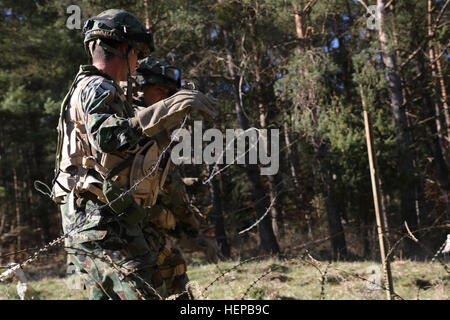 Bulgarische Soldaten der Engineer Platoon erstrecken sich schlicht Stacheldraht, Streikposten Stahl, wie sie einen Draht Hindernis während des Trainings Saber Kreuzung 15 bei der US Army Joint Multinational Readiness Center in Hohenfels, Deutschland, 21. April 2015 konstruieren zu sichern. Säbel Kreuzung 15 bereitet NATO und Partnerland Streitkräfte für Offensive und Defensive Stabilität Operationen und fördert die Interoperabilität zwischen den Teilnehmern. Säbel Kreuzung 15 hat mehr als 4.700 Teilnehmer aus 17 Ländern enthalten: Albanien, Armenien, Belgien, Bosnien, Bulgarien, Großbritannien, Ungarn, Lettland, Litauen, Mitglied Stockfoto