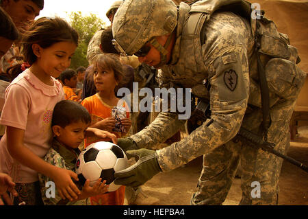 US-Soldaten aus dem 2. Eskadron, 14. Kavallerie-Regiment 25. Infanterie-Division, teilen Sie Fußbälle an irakische Kinder in einem kooperativen medizinischen Engagement in Hor Al Bosh, Irak, 30. Juli 2008 statt. (US-Armee Fotos von Spc. Daniel Herrera/freigegeben) Koalition Verhalten kooperative medizinische Engagement 107716 Stockfoto