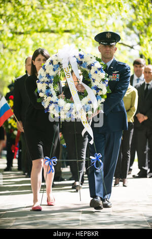 State Department Vertreter legen einen Kranz im Rahmen einer Feierstunde durch den Geist der Elbe Markierung in Abschnitt 7A des Arlington National Cemetery, 24. April 2015, in Arlington, VA. Die Markierung, wo die Zeremonie stattfindet, lautet: "als Anerkennung für die Zusammenarbeit von amerikanischen und sowjetischen Alliierten Streitkräfte während des zweiten Weltkriegs. Dieser Marker symbolisiert den Link oben von sowjetischen und amerikanischen Elementen an der Elbe am 15. April 1945. In Gedenken an die Partnerschaft im Kampf gegen die Tyrannei." (US Armee-Foto von Rachel Larue/freigegeben) Kranzniederlegung am Geist der Elbe in Arlington nationalen Cemeter Stockfoto