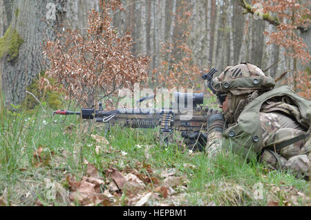 Ein US-Soldat von Alpha Company, 3. Bataillon, 69. Armor Regiment, feuert ein leichtes Maschinengewehr M249 bei gegensätzlicher Kräfte während der Durchführung eines Wasserhindernisses mit gegensätzlichen Kräfte Szenario während des Trainings Letzlingen Freiheit Schock bei der GACTC in Letzlingen, Deutschland, 25. April 2015. Übung Letzlingen Freiheit Schock fördert die Interoperabilität zwischen den deutschen und amerikanischen Training Organisationen wobei US Army Europe rapid Bereitstellungsfunktionen. (US Armee-Foto von Sgt. Ian Schell/freigegeben) Übung Letzlingen Freiheit Schock 150425-A-IR813-010 Stockfoto