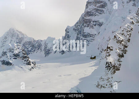 Berge der Alaskakette Zwerg ein CH-47F Chinook Hubschrauber aus D Company, 1. Bataillon, 52. Aviation Regiment trägt Ausrüstung und liefert aus Talkeetna an den Kahiltna Gletscher Basislager am Mount McKinley 27. April 2015. Soldaten und Chinooks aus D/1-52d "Zucker-Bären" machten kurzen Prozess liefern mehrere tausend Pfund Ausrüstung lagern bei 7.000 und 14.000 Fuß für die Klettersaison 2015 stützen sparen Zeit und Geld für die National Park Service und Betrieb in Höhenlagen und unschätzbare Erfahrungen im Gelände nicht verfügbar für Trainingsmissionen außerhalb Alask Stockfoto